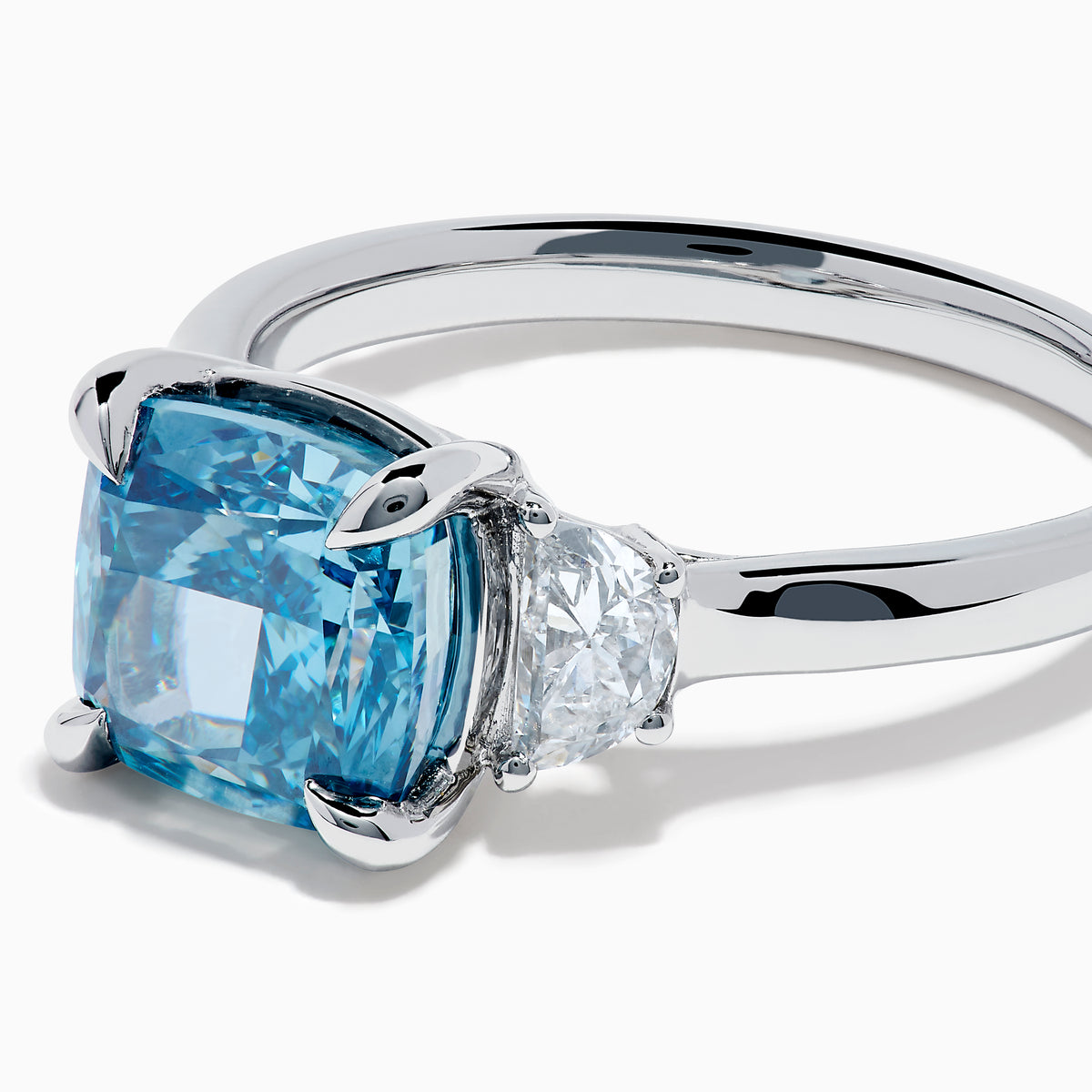 Lab Grown Blue and White Diamond 3-Stone Ring in 14K White Gold, featuring a prominent cushion-cut blue and white diamond center with two clear triangular side stones, shown on a white background.