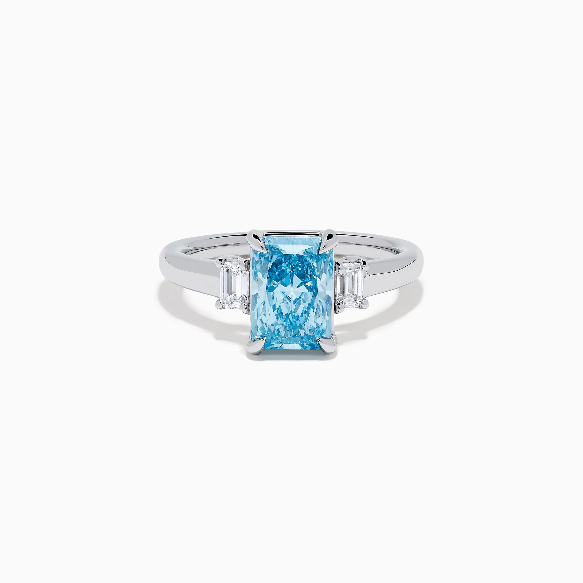 The Lab Grown Blue Diamond 3-Stone Ring in 14K White Gold features a brilliant blue center diamond with two clear rectangular side stones, set in sleek white gold against a crisp white background.