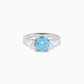 The Lab Grown Blue and White Diamond 3 Stone Ring in 14K White Gold features a striking round blue gemstone center with two rectangular lab grown diamonds on each side, all set in elegant white gold.