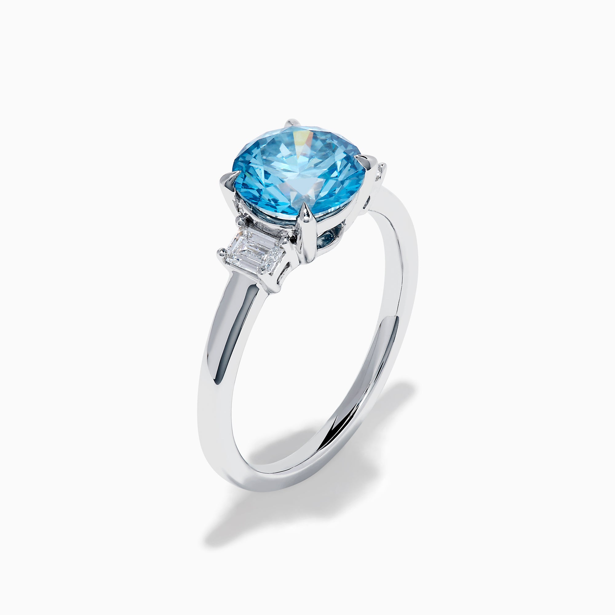 The Lab Grown Blue and White Diamond 3 Stone Ring in 14K White Gold features a striking round blue gemstone center with two rectangular lab grown diamonds on each side, all set in elegant white gold.