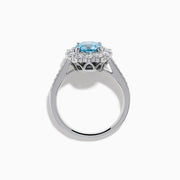 The Lab Grown Blue and White Diamond Halo Ring in 14K White Gold showcases a striking round blue center stone, encircled by lab grown diamond accents and additional diamonds adorning the band.