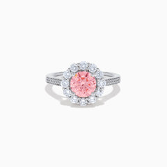 The Lab Grown Pink and White Diamond Halo Ring in 14K White Gold features a round pink gemstone center, surrounded by a halo of lab grown diamonds and additional diamonds along the elegant band.