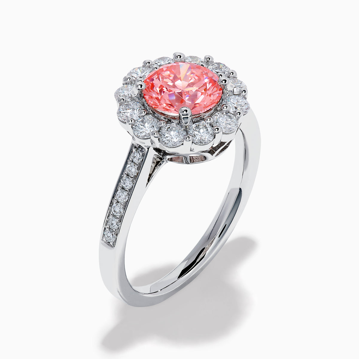 The Lab Grown Pink and White Diamond Halo Ring in 14K White Gold features a round pink gemstone center, surrounded by a halo of lab grown diamonds and additional diamonds along the elegant band.