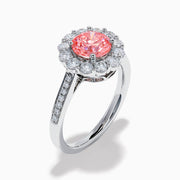 The Lab Grown Pink and White Diamond Halo Ring in 14K White Gold features a round pink gemstone center, surrounded by a halo of lab grown diamonds and additional diamonds along the elegant band.