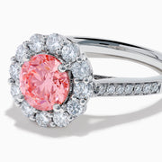 The Lab Grown Pink and White Diamond Halo Ring in 14K White Gold features a round pink gemstone center, surrounded by a halo of lab grown diamonds and additional diamonds along the elegant band.