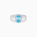 The Lab Grown Blue and White Diamond 3-Stone Ring in 14K White Gold showcases an oval blue centerpiece with two pear-shaped lab grown diamonds on each side, all set in elegant white gold.