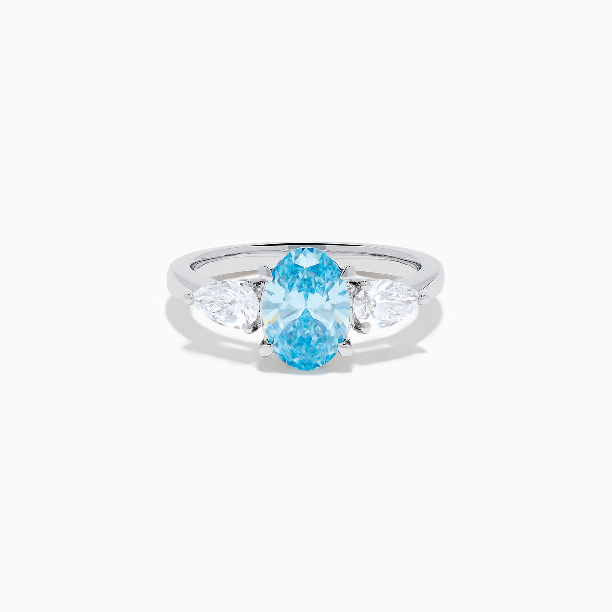 The Lab Grown Blue and White Diamond 3-Stone Ring in 14K White Gold showcases an oval blue centerpiece with two pear-shaped lab grown diamonds on each side, all set in elegant white gold.