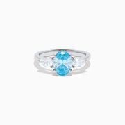 The Lab Grown Blue and White Diamond 3-Stone Ring in 14K White Gold showcases an oval blue centerpiece with two pear-shaped lab grown diamonds on each side, all set in elegant white gold.