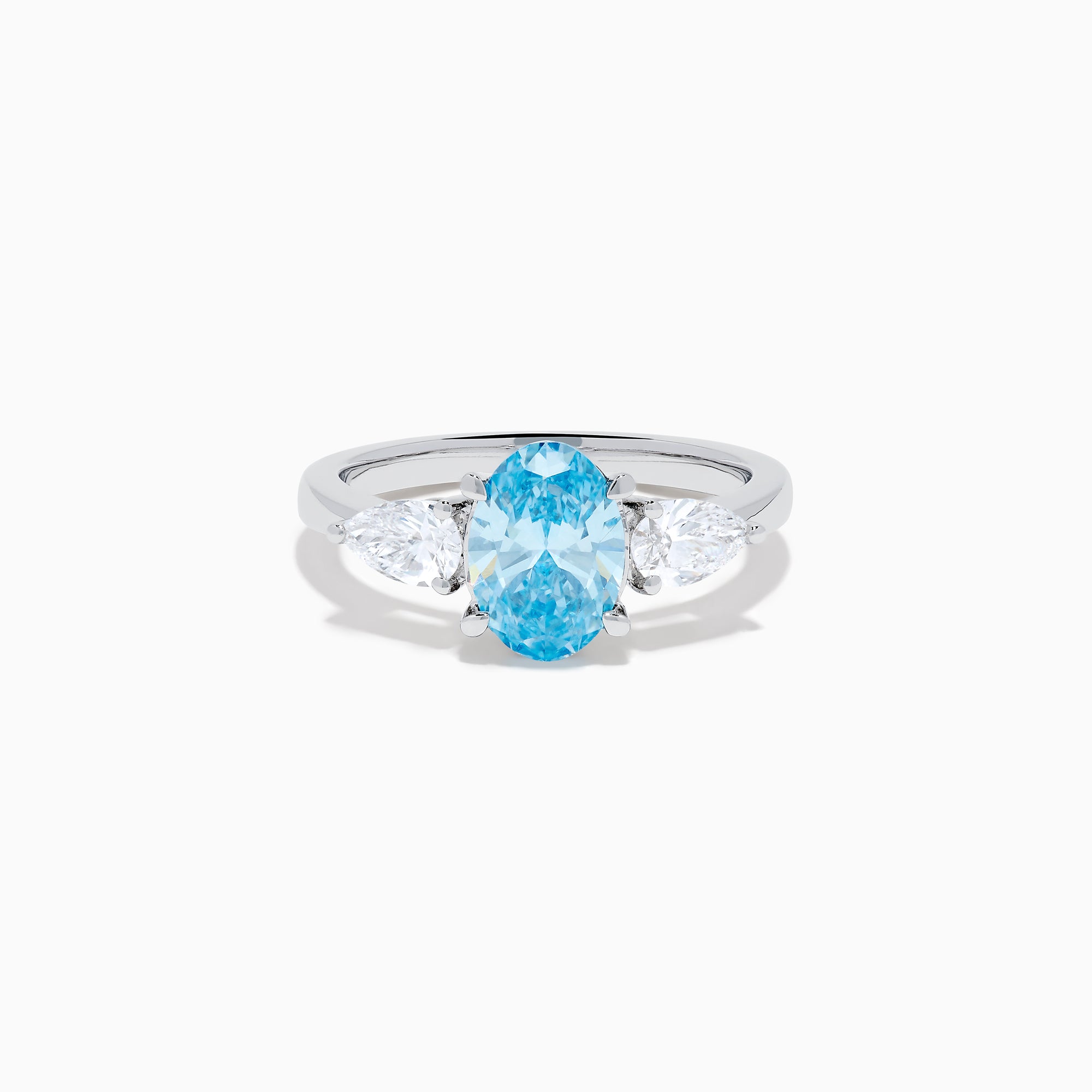 The Lab Grown Blue and White Diamond 3-Stone Ring in 14K White Gold showcases an oval blue centerpiece with two pear-shaped lab grown diamonds on each side, all set in elegant white gold.