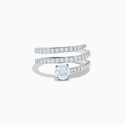 The Lab Grown Diamond Wrap Around Round Ring in 14K white gold showcases three curved, diamond-studded bands and a large round lab diamond at the center, set against a white background.