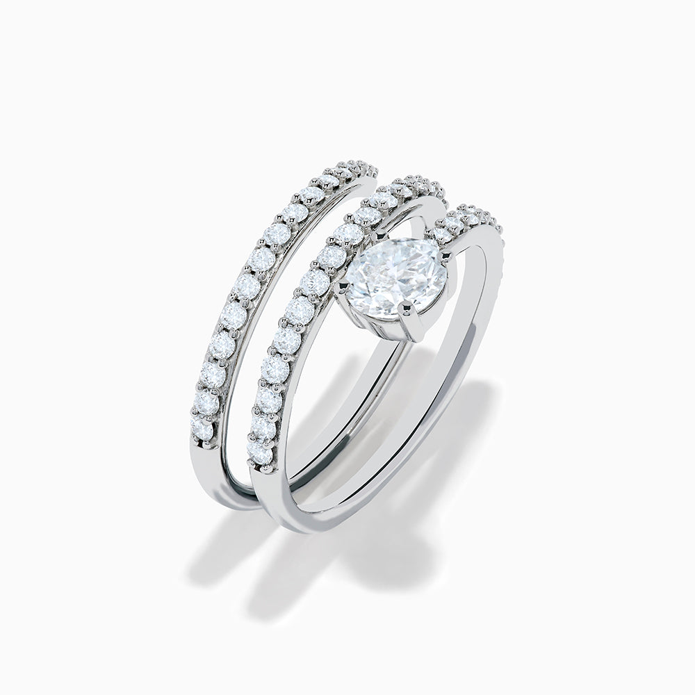 The Lab Grown Diamond Wrap Around Round Ring in 14K white gold showcases three curved, diamond-studded bands and a large round lab diamond at the center, set against a white background.
