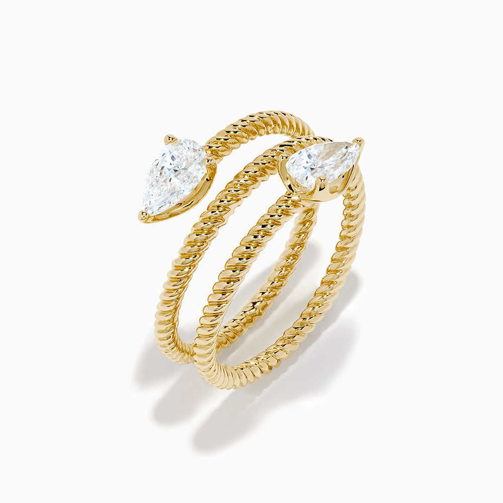 A Lab Grown Diamond Wrap around Toi et Moi Ring in 14K Yellow Gold features an open twisted band with two pear-shaped diamonds at each end, shown on a plain white background.