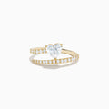 The Lab Grown Diamond Wrap Around Heart Ring in 14K Yellow Gold showcases a heart-shaped center stone and two open bands adorned with diamonds, elegantly displayed on a white background.