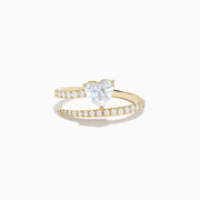 The Lab Grown Diamond Wrap Around Heart Ring in 14K Yellow Gold showcases a heart-shaped center stone and two open bands adorned with diamonds, elegantly displayed on a white background.