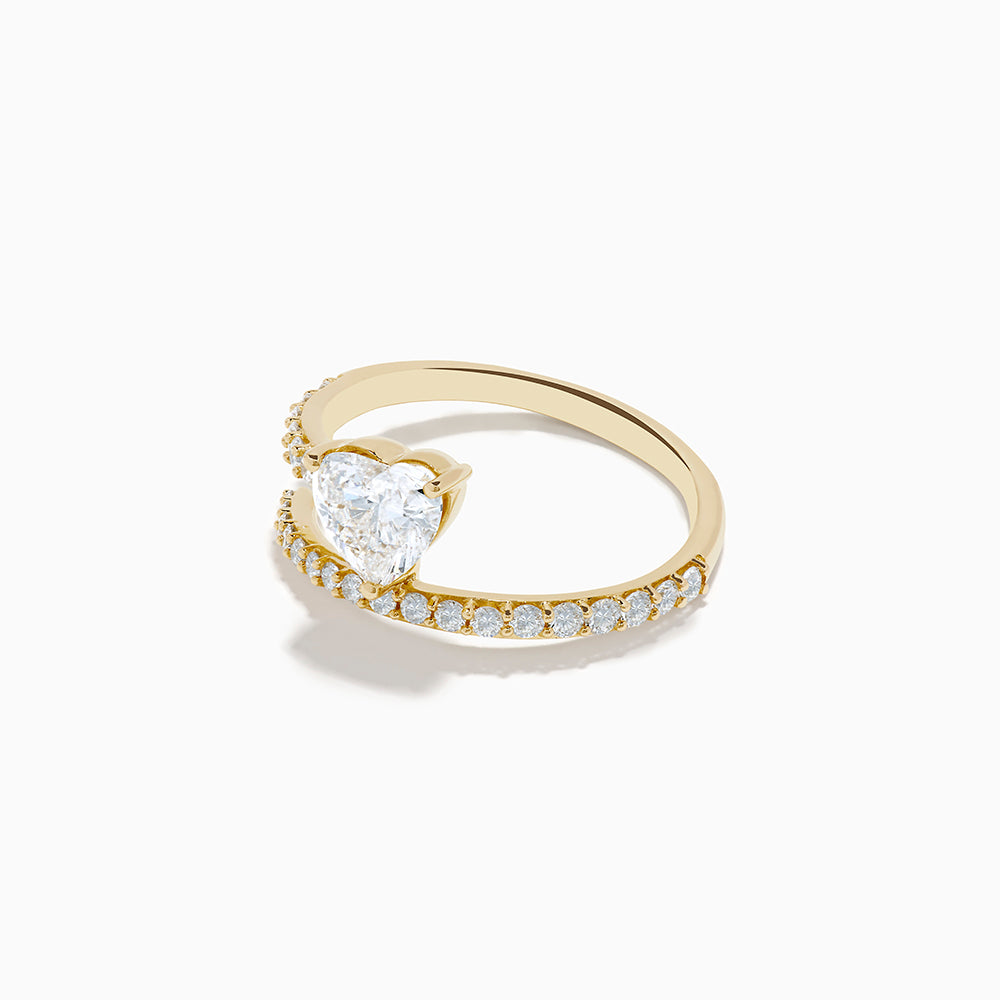 The Lab Grown Diamond Wrap Around Heart Ring in 14K Yellow Gold showcases a heart-shaped center stone and two open bands adorned with diamonds, elegantly displayed on a white background.