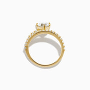 The Lab Grown Diamond Wrap Around Heart Ring in 14K Yellow Gold showcases a heart-shaped center stone and two open bands adorned with diamonds, elegantly displayed on a white background.