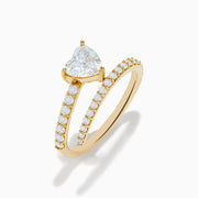 The Lab Grown Diamond Wrap Around Heart Ring in 14K Yellow Gold showcases a heart-shaped center stone and two open bands adorned with diamonds, elegantly displayed on a white background.