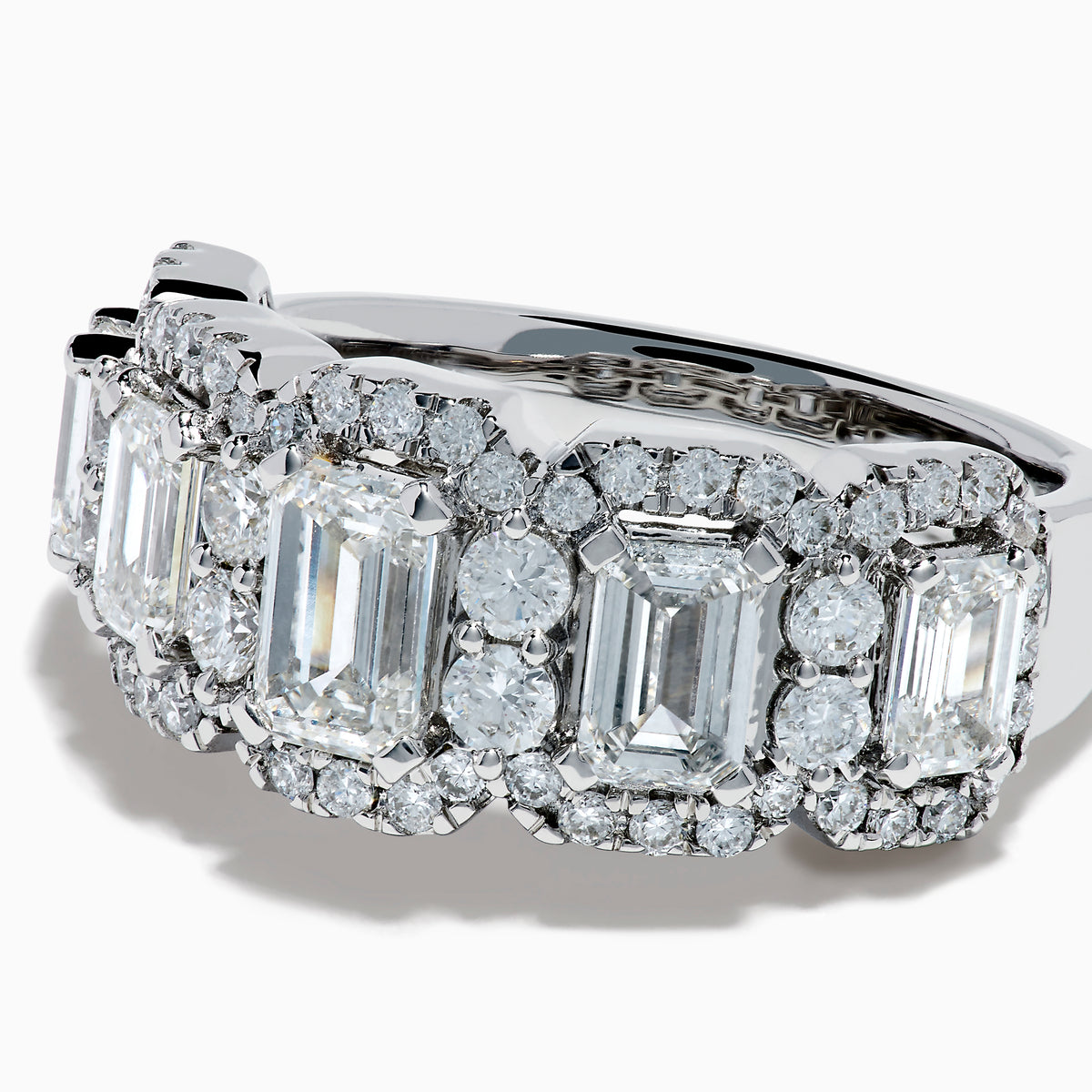 The Lab Grown Emerald Cut Diamond Halo Band in 14K White Gold showcases a luxurious row of large emerald-cut lab grown diamonds, accented by smaller round diamonds in an intricate halo design.