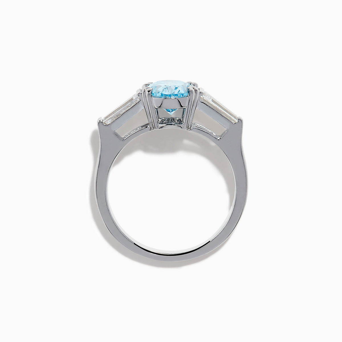 The Lab Grown Blue and White Diamond 3-Stone Ring in 14K White Gold showcases an oval blue diamond flanked by tapered white baguette diamonds, all set against a plain white background.