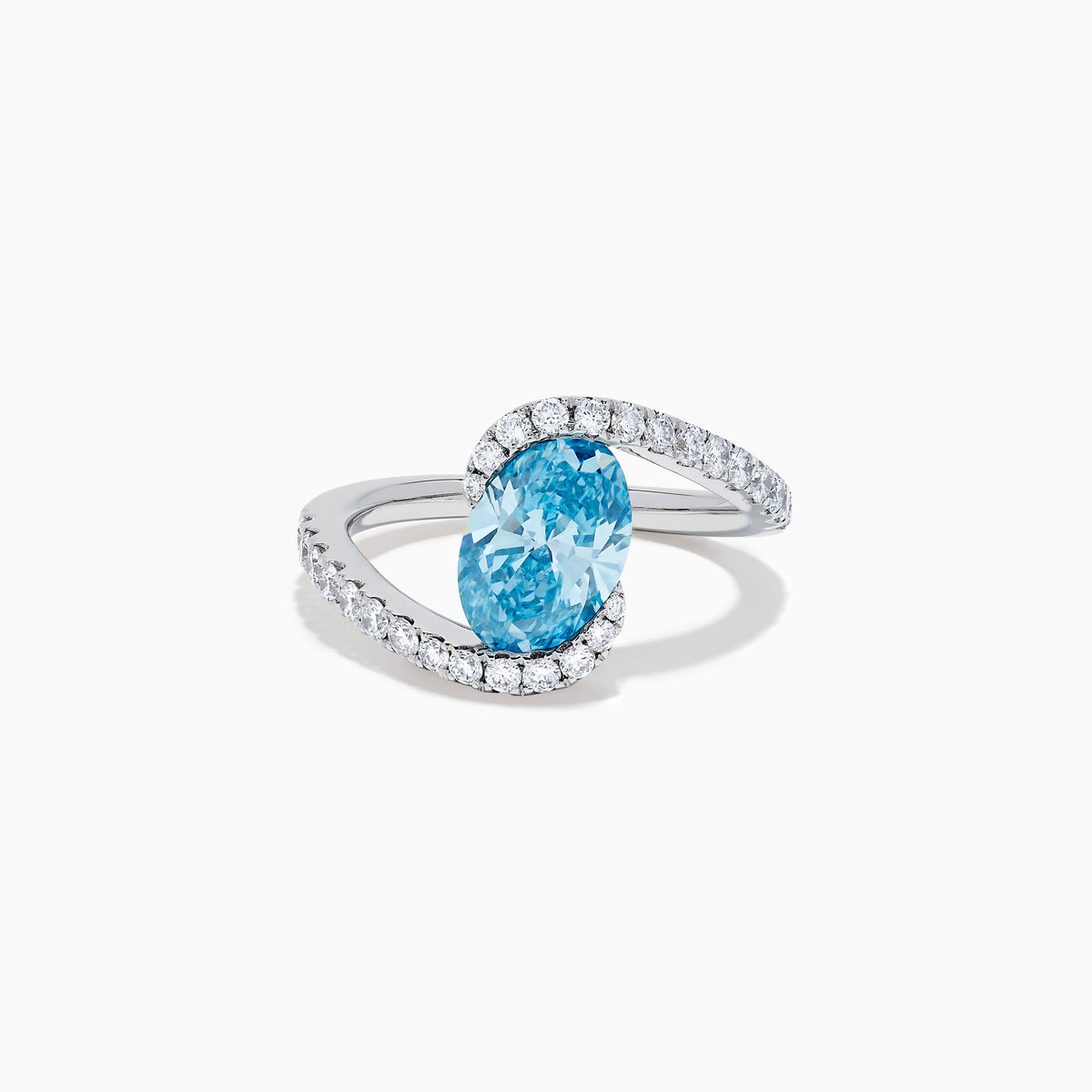 The Lab Grown Blue and White Diamond Connect Ring in 14K White Gold features an oval blue gemstone center, accented with lab grown diamonds on a curved band, shown against a plain white background.