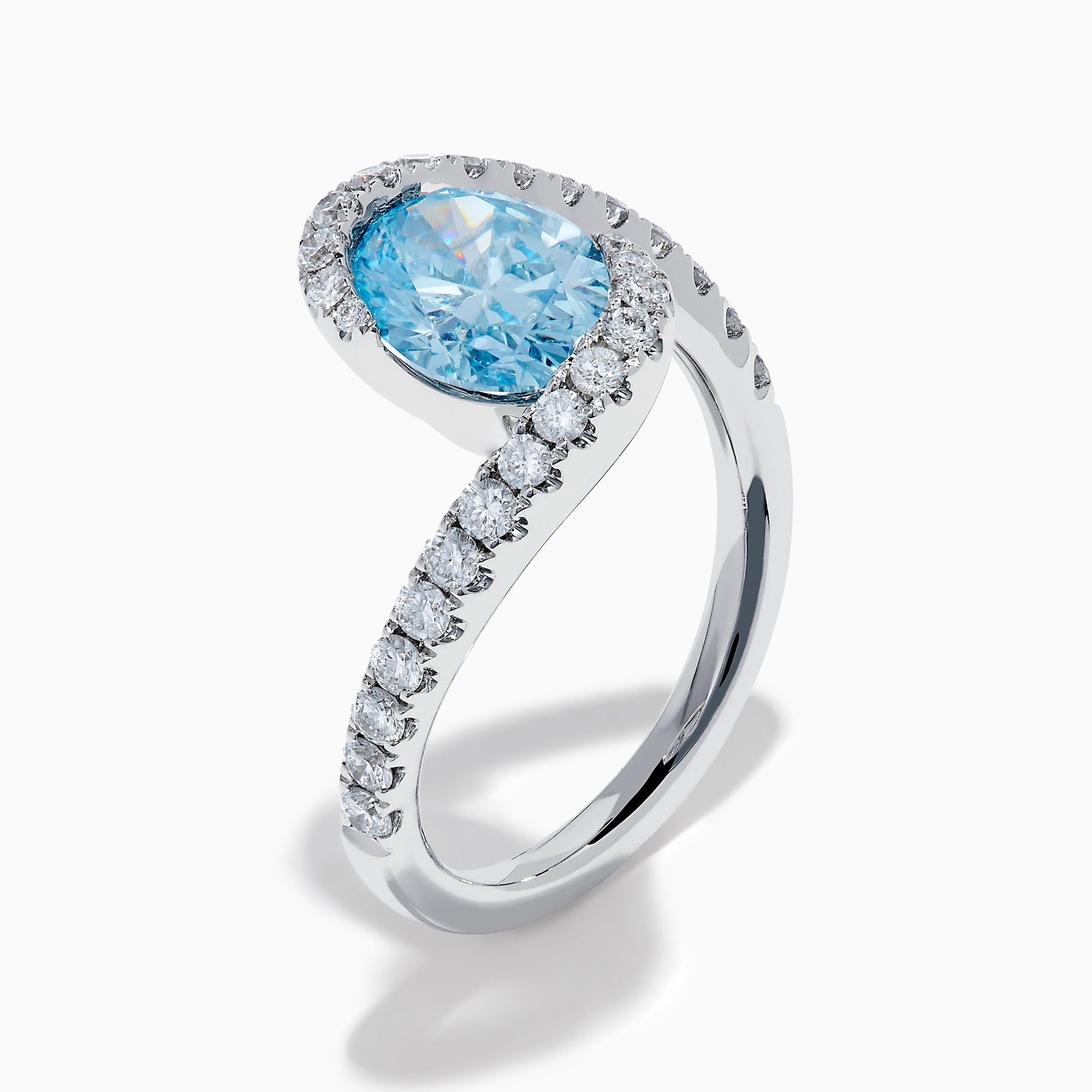 The Lab Grown Blue and White Diamond Connect Ring in 14K White Gold features an oval blue gemstone center, accented with lab grown diamonds on a curved band, shown against a plain white background.