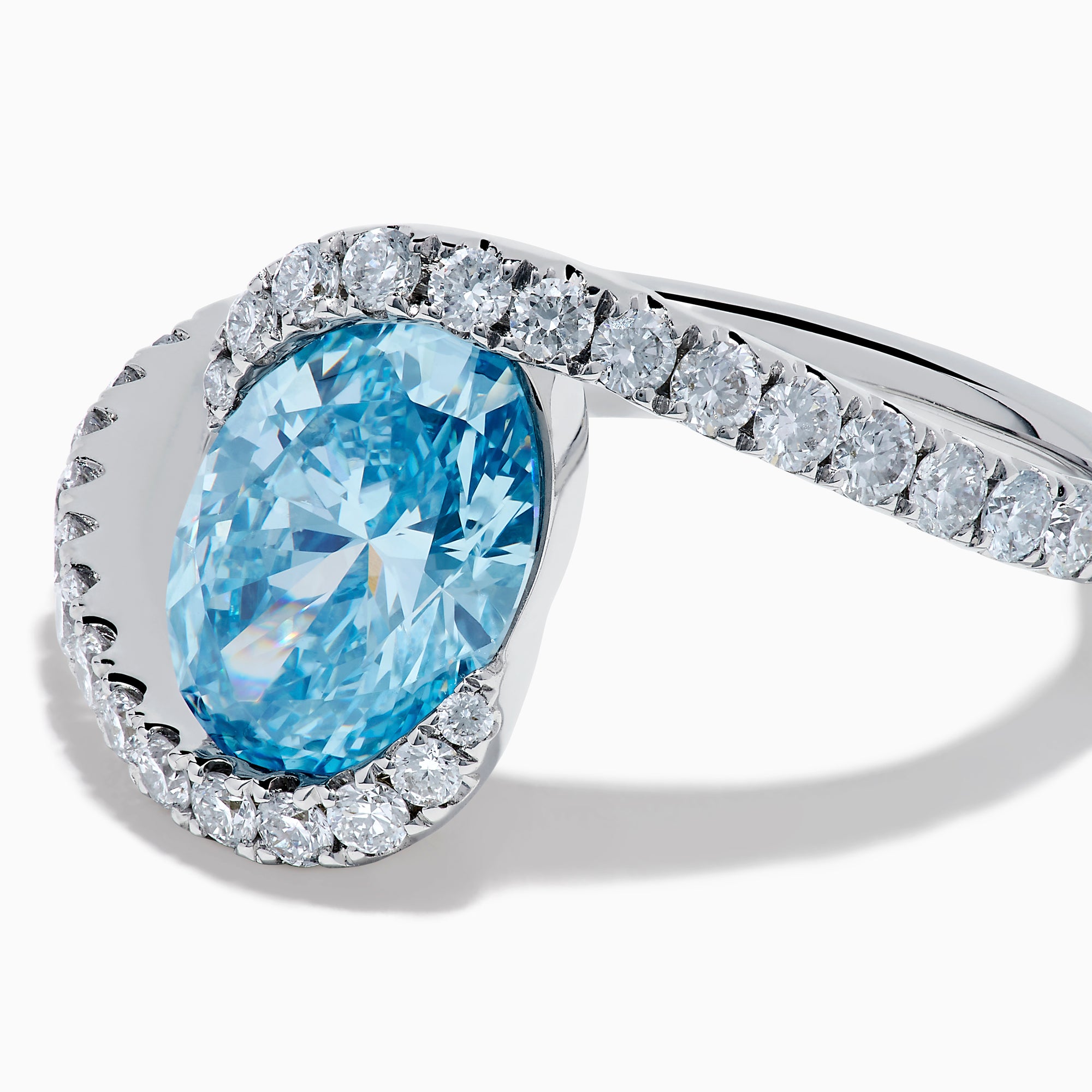 The Lab Grown Blue and White Diamond Connect Ring in 14K White Gold features an oval blue gemstone center, accented with lab grown diamonds on a curved band, shown against a plain white background.