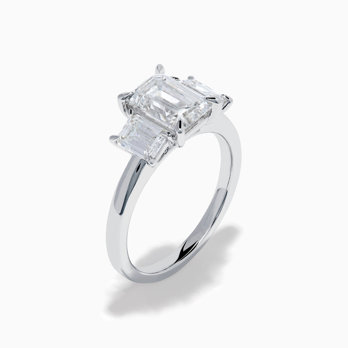 The Lab Grown Emerald Cut Diamond 3 Stone Ring in 14K White Gold features a central emerald-cut lab-grown diamond flanked by two rectangular diamonds on each side.