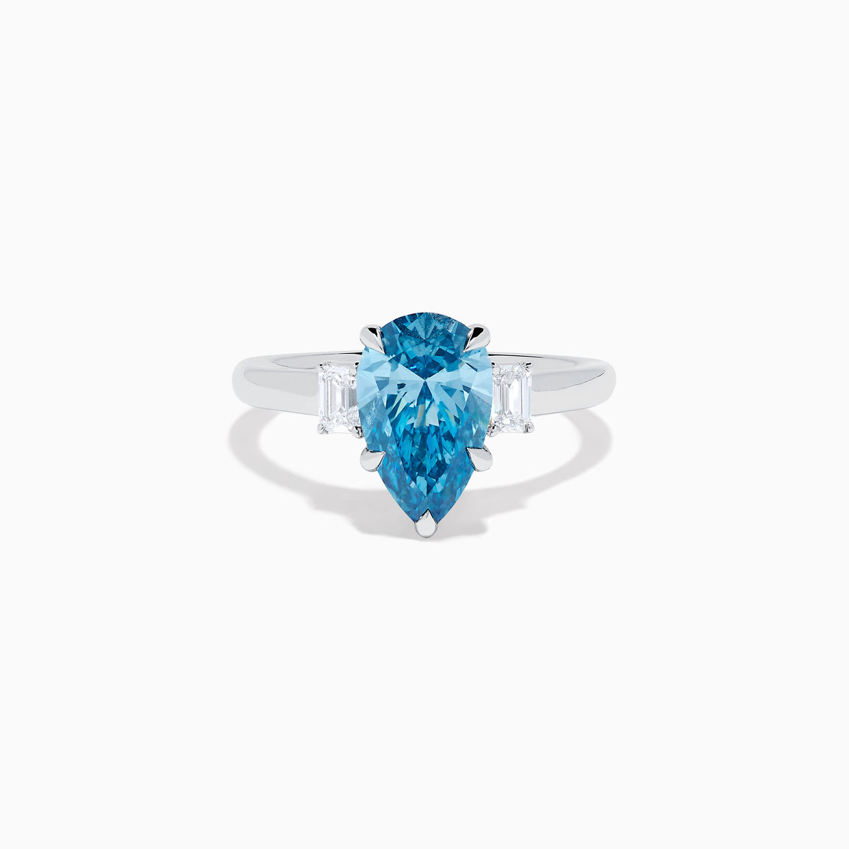 The Lab Grown Blue and White Diamond 3-Stone Ring in 14K White Gold features a large pear-shaped blue gemstone center with two rectangular lab grown diamonds, all set in white gold and displayed on a white background.