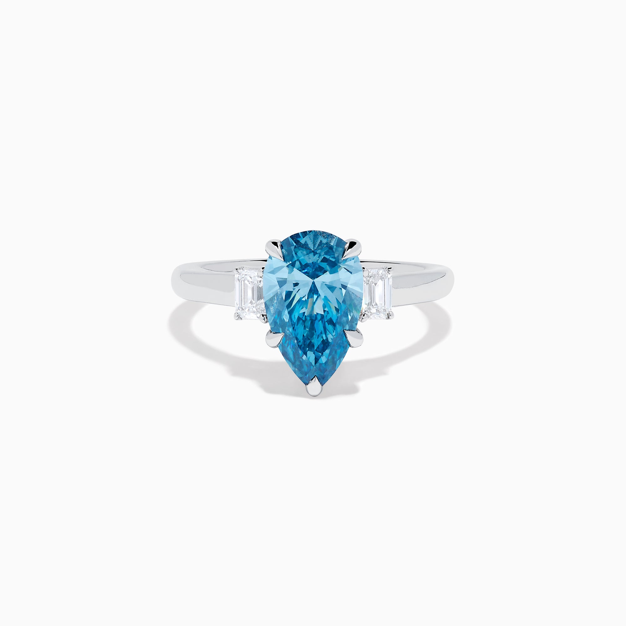 The Lab Grown Blue and White Diamond 3-Stone Ring in 14K White Gold features a large pear-shaped blue gemstone center with two rectangular lab grown diamonds, all set in white gold and displayed on a white background.