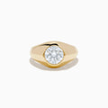 The Lab Grown Diamond Bezel Signet Pinky Ring in 14K Yellow Gold features a wide band and a large, round lab grown diamond at the center, shown against a plain white background.