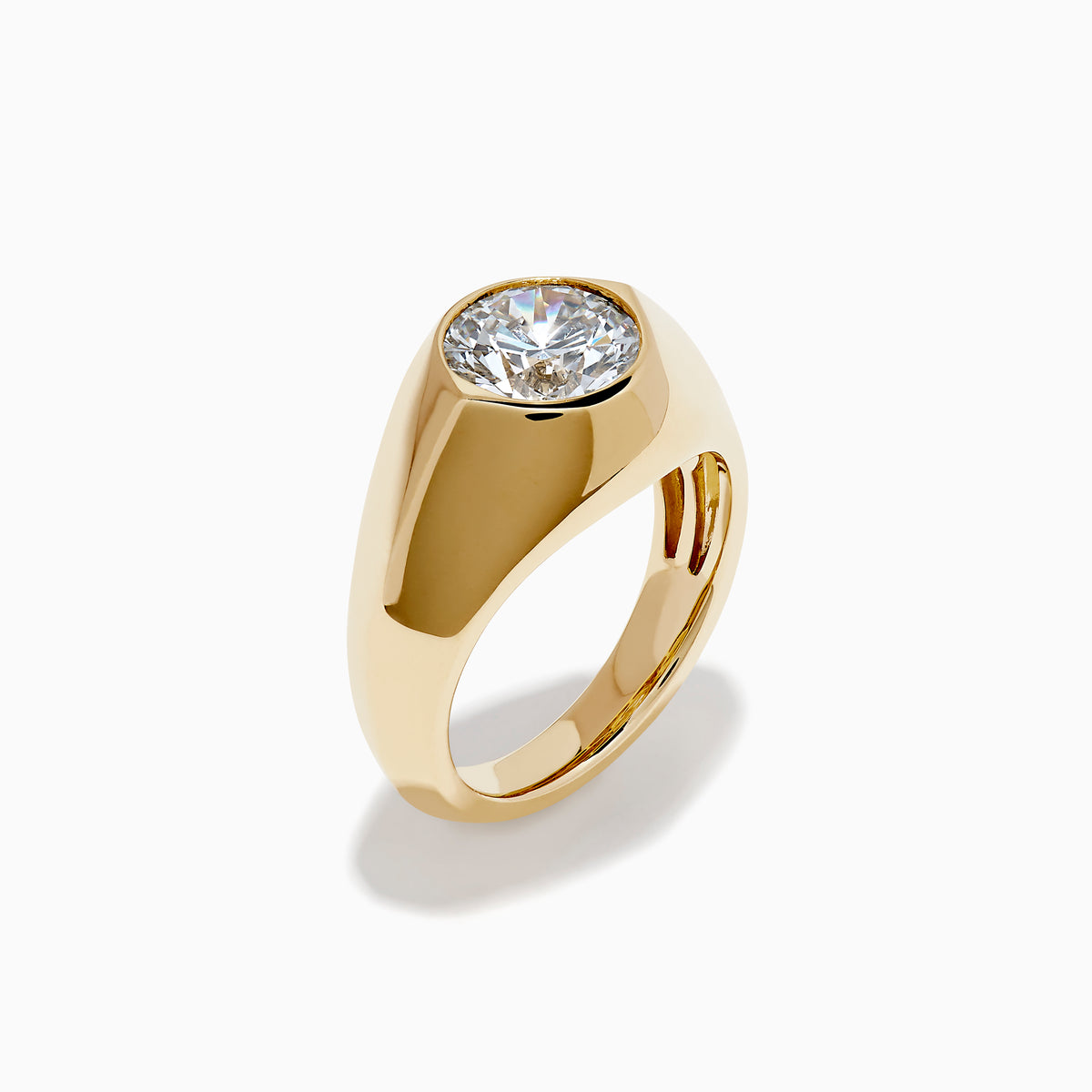 The Lab Grown Diamond Bezel Signet Pinky Ring in 14K Yellow Gold features a wide band and a large, round lab grown diamond at the center, shown against a plain white background.