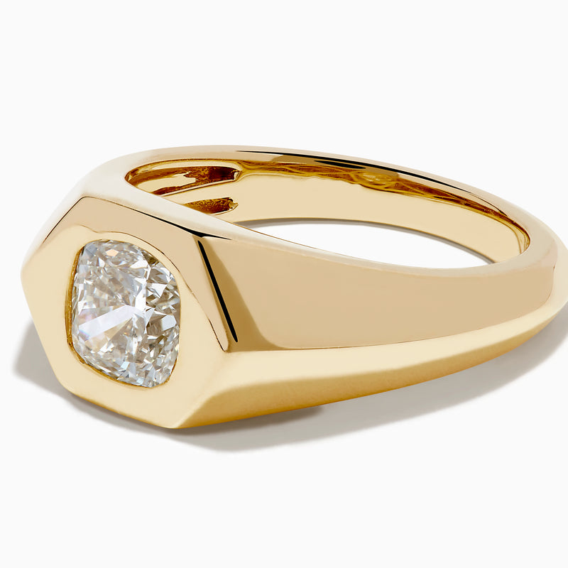 The Lab Grown Diamond Cushion Bezel Signet Pinky Ring in 14K Yellow Gold features a broad band with a cushion-cut lab-grown diamond set in a polished bezel, shown on a plain white background.