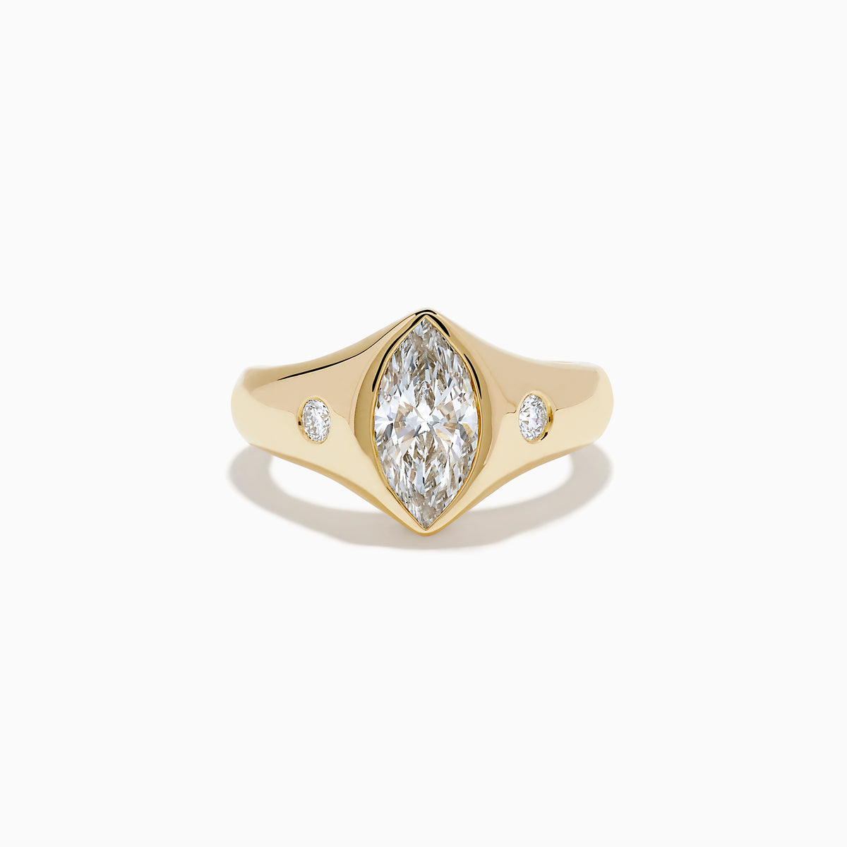 The Lab Grown Diamond Marquise Bezel Pinky Ring in 14K Yellow Gold features a central marquise lab grown diamond, accented by two small round diamonds on each side, all set on a sleek, polished band.