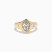 The Lab Grown Diamond Marquise Bezel Pinky Ring in 14K Yellow Gold features a central marquise lab grown diamond, accented by two small round diamonds on each side, all set on a sleek, polished band.