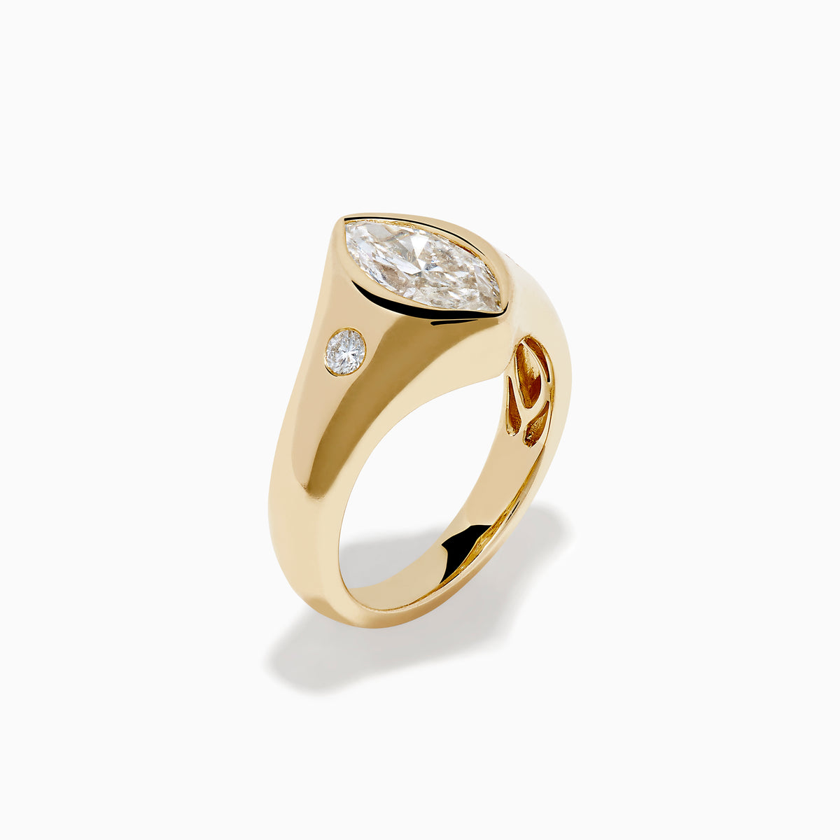 The Lab Grown Diamond Marquise Bezel Pinky Ring in 14K Yellow Gold features a central marquise lab grown diamond, accented by two small round diamonds on each side, all set on a sleek, polished band.