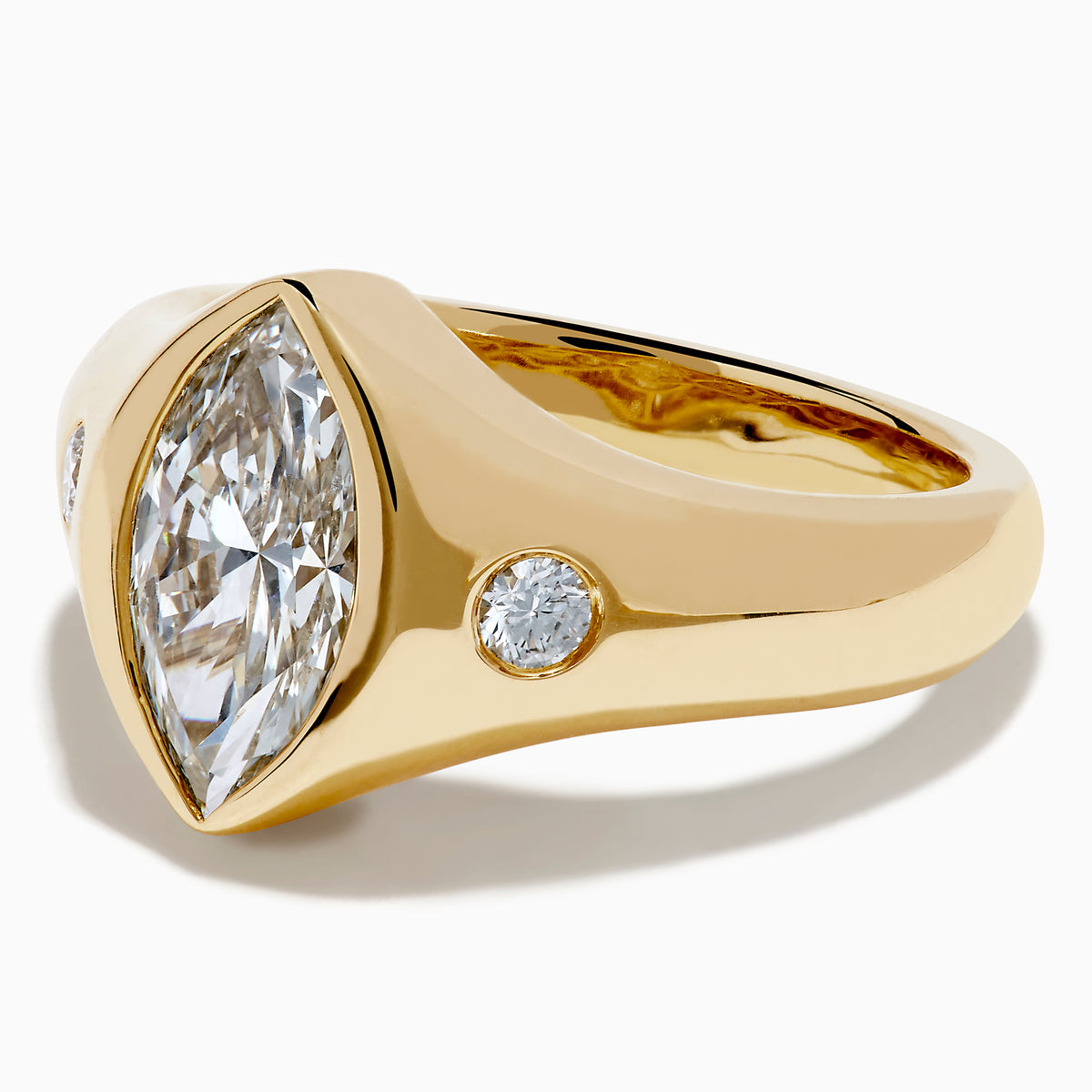 The Lab Grown Diamond Marquise Bezel Pinky Ring in 14K Yellow Gold features a central marquise lab grown diamond, accented by two small round diamonds on each side, all set on a sleek, polished band.