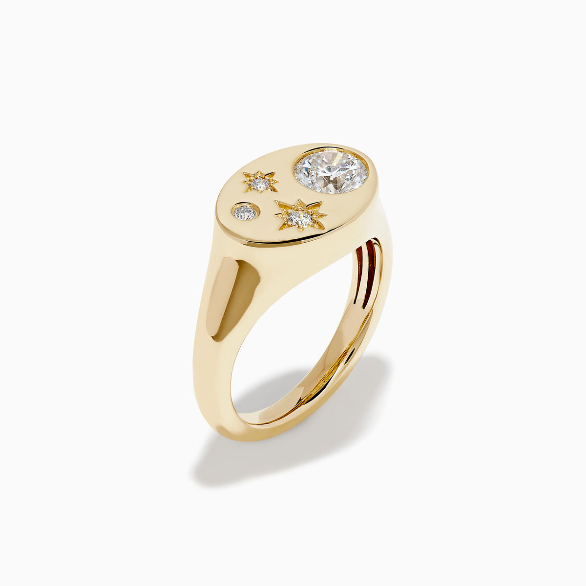 The Lab Grown Diamond Celestial Signet Pinky Ring in 14K Yellow Gold features a flat oval face with three star-shaped lab grown diamonds and one larger round diamond.
