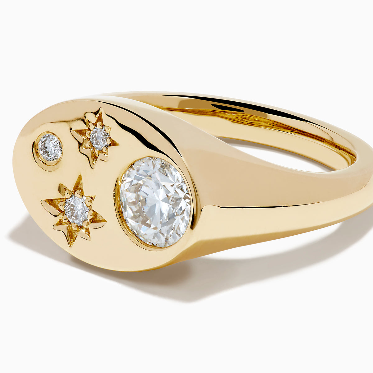 The Lab Grown Diamond Celestial Signet Pinky Ring in 14K Yellow Gold features a flat oval face with three star-shaped lab grown diamonds and one larger round diamond.
