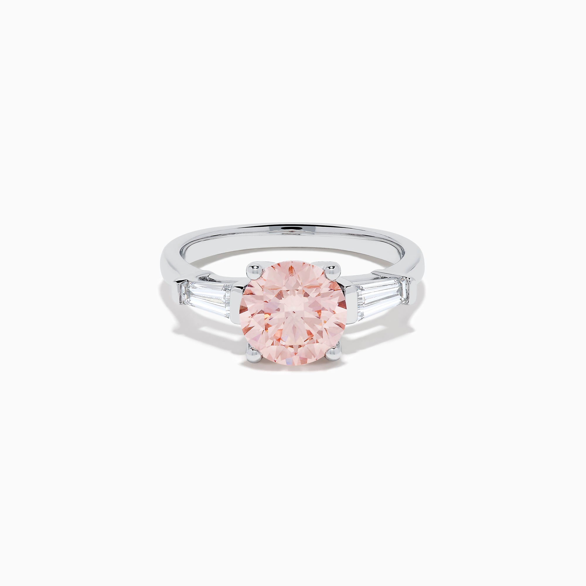 The Lab Grown Pink and White Diamond 3 Stone Ring in 14K White Gold features a striking round pink center stone with two rectangular white diamonds on each side, set against a white background.