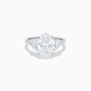 The Lab Grown Oval Diamond 3 Stone Ring in 14K White Gold features a striking lab grown oval diamond center, accented by two pear-shaped diamonds on each side.