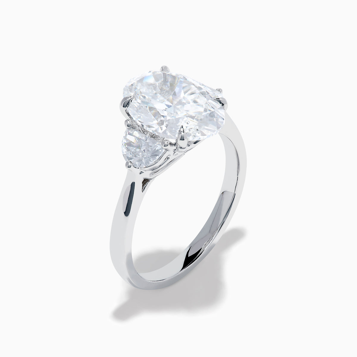The Lab Grown Oval Diamond 3 Stone Ring in 14K White Gold features a striking lab grown oval diamond center, accented by two pear-shaped diamonds on each side.