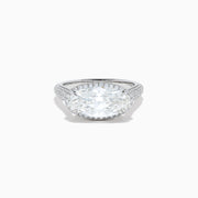 The Lab Grown Diamond East-West Oval Halo Ring in 14K White Gold showcases a brilliant lab-grown diamond center, accented by sparkling stones along the band, beautifully set against a plain white background.