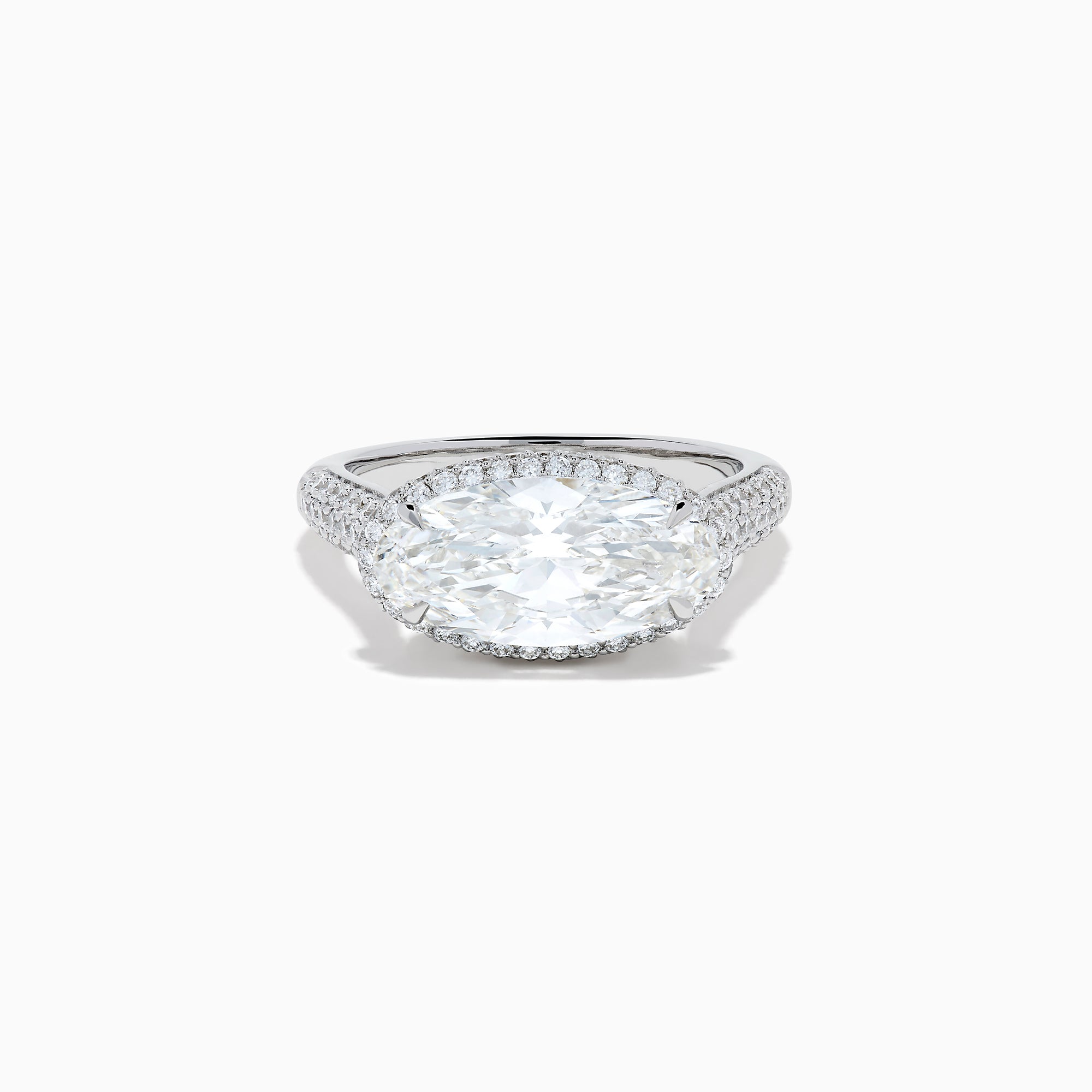 The Lab Grown Diamond East-West Oval Halo Ring in 14K White Gold showcases a brilliant lab-grown diamond center, accented by sparkling stones along the band, beautifully set against a plain white background.