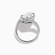 The Lab Grown Diamond Elongated Oval Halo Ring in 14K White Gold showcases a large oval lab diamond center, haloed by smaller diamonds with a diamond-adorned split shank, displayed on a clean white background.