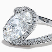 The Lab Grown Diamond Elongated Oval Halo Ring in 14K White Gold showcases a large oval lab diamond center, haloed by smaller diamonds with a diamond-adorned split shank, displayed on a clean white background.