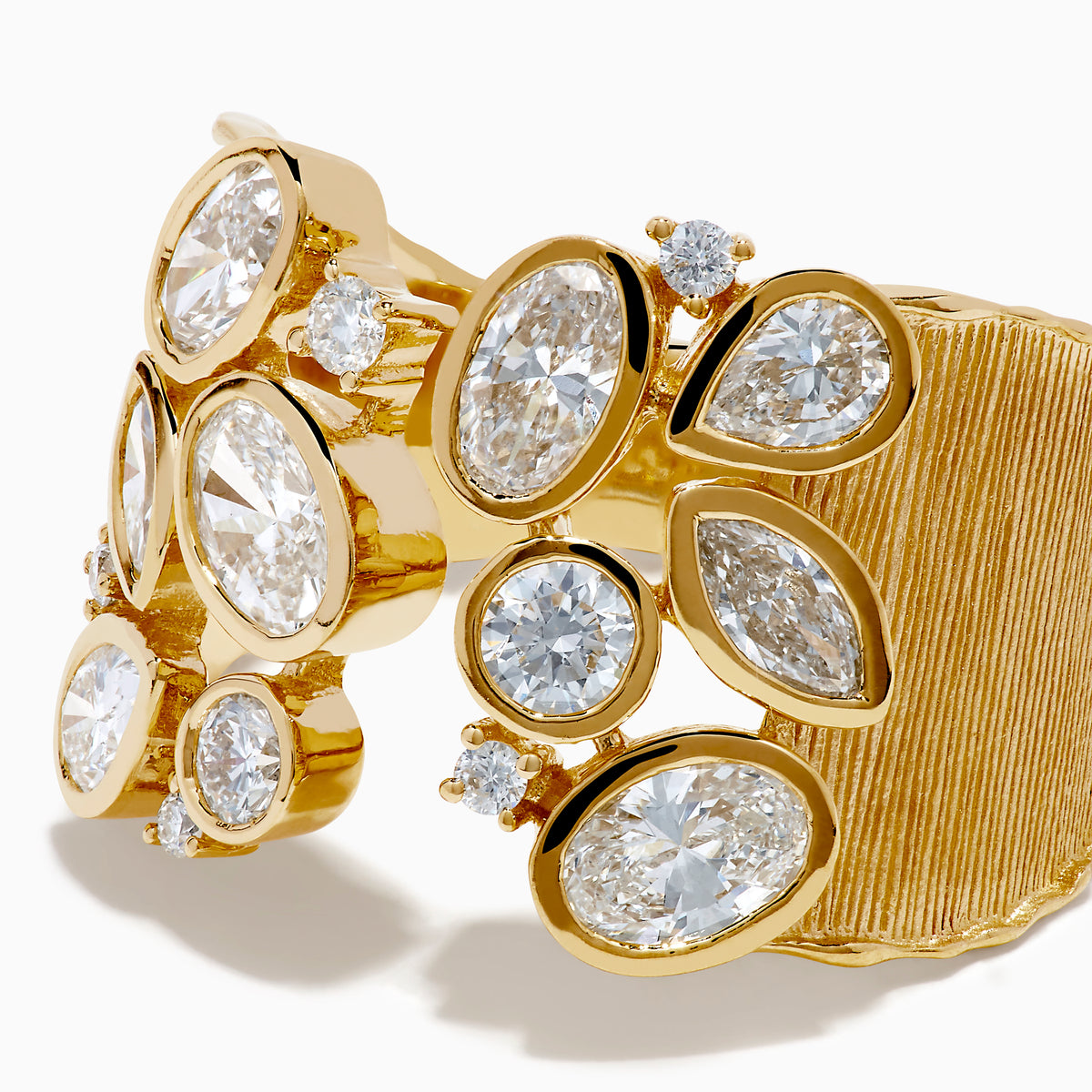 The Lab Grown Multi Shape Diamond Open Shank Textured Ring in 14K Yellow Gold features an open front with oval and marquise lab-grown diamonds arranged in a scattered, leaf-inspired pattern.