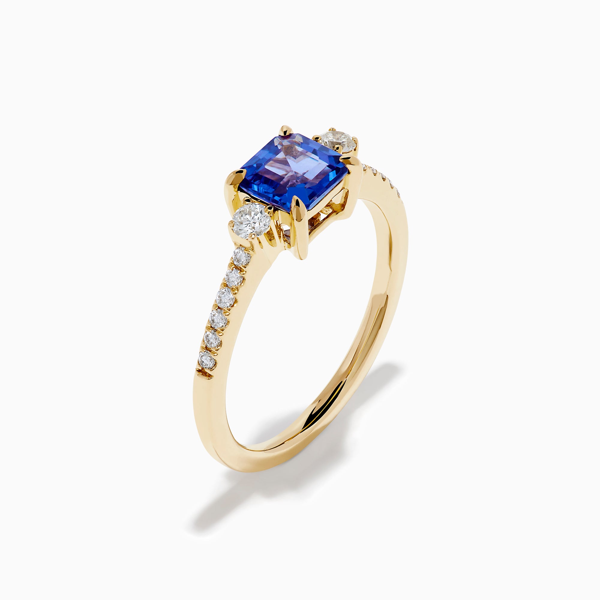 The 14K Yellow Gold Tanzanite and Diamond Ring showcases a square-cut blue tanzanite centerpiece, accented by round white diamonds set along the band.