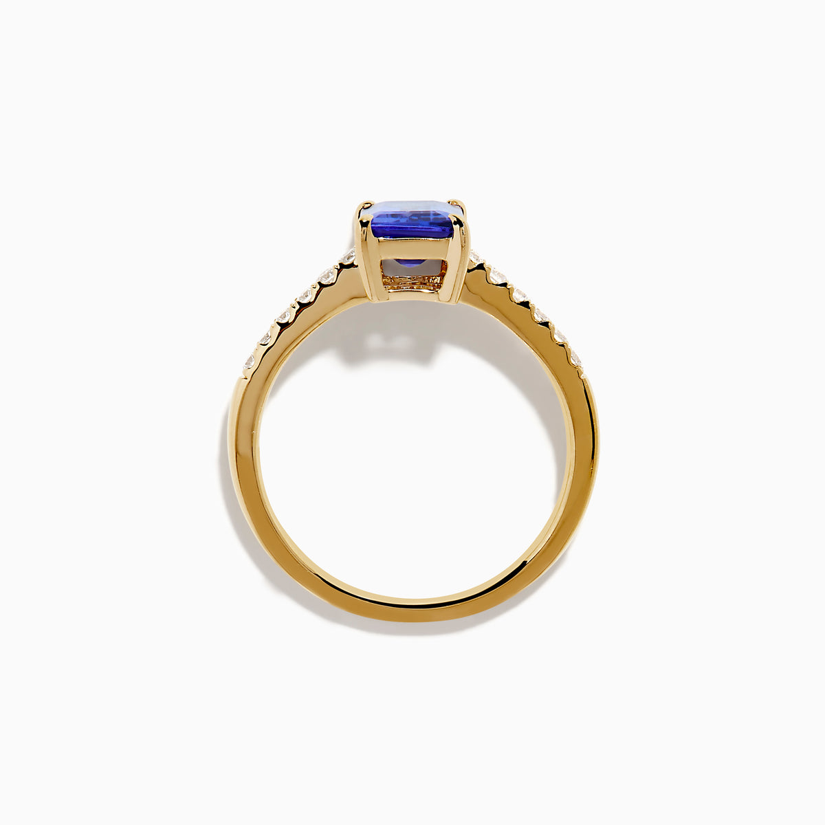 The Nahla 14K Yellow Gold Tanzanite and Diamond Ring showcases a rectangular blue tanzanite center stone, accented by small round white diamonds along the upper band on a plain white background—timeless elegance in every detail.