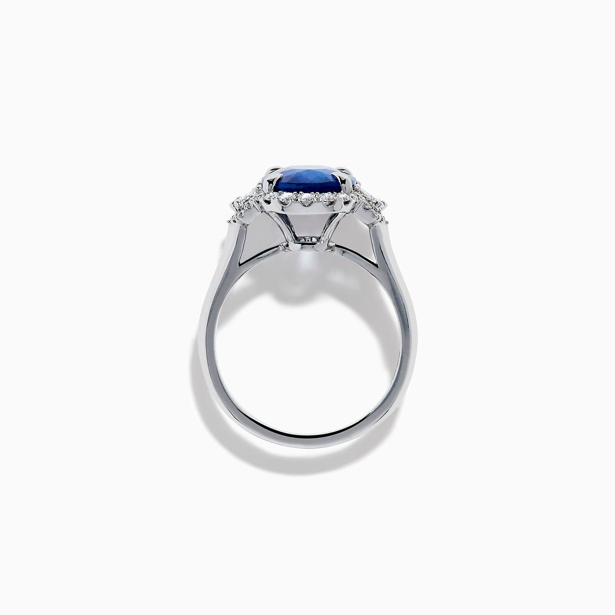 The Effy Hematian 18K White Gold Blue Sapphire and Diamond Halo Ring features a striking oval blue sapphire center, surrounded by round and rectangular diamonds, showcased on a plain white background.
