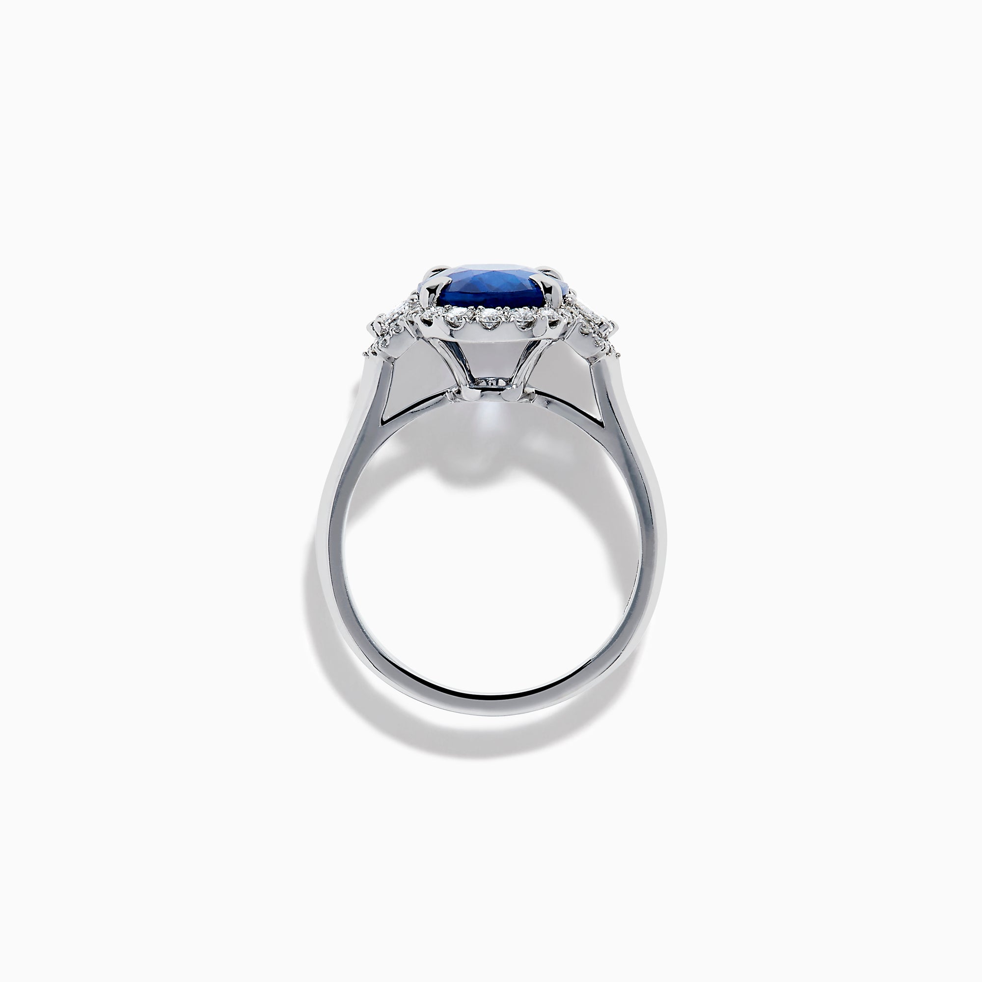 The Effy Hematian 18K White Gold Blue Sapphire and Diamond Halo Ring features a striking oval blue sapphire center, surrounded by round and rectangular diamonds, showcased on a plain white background.